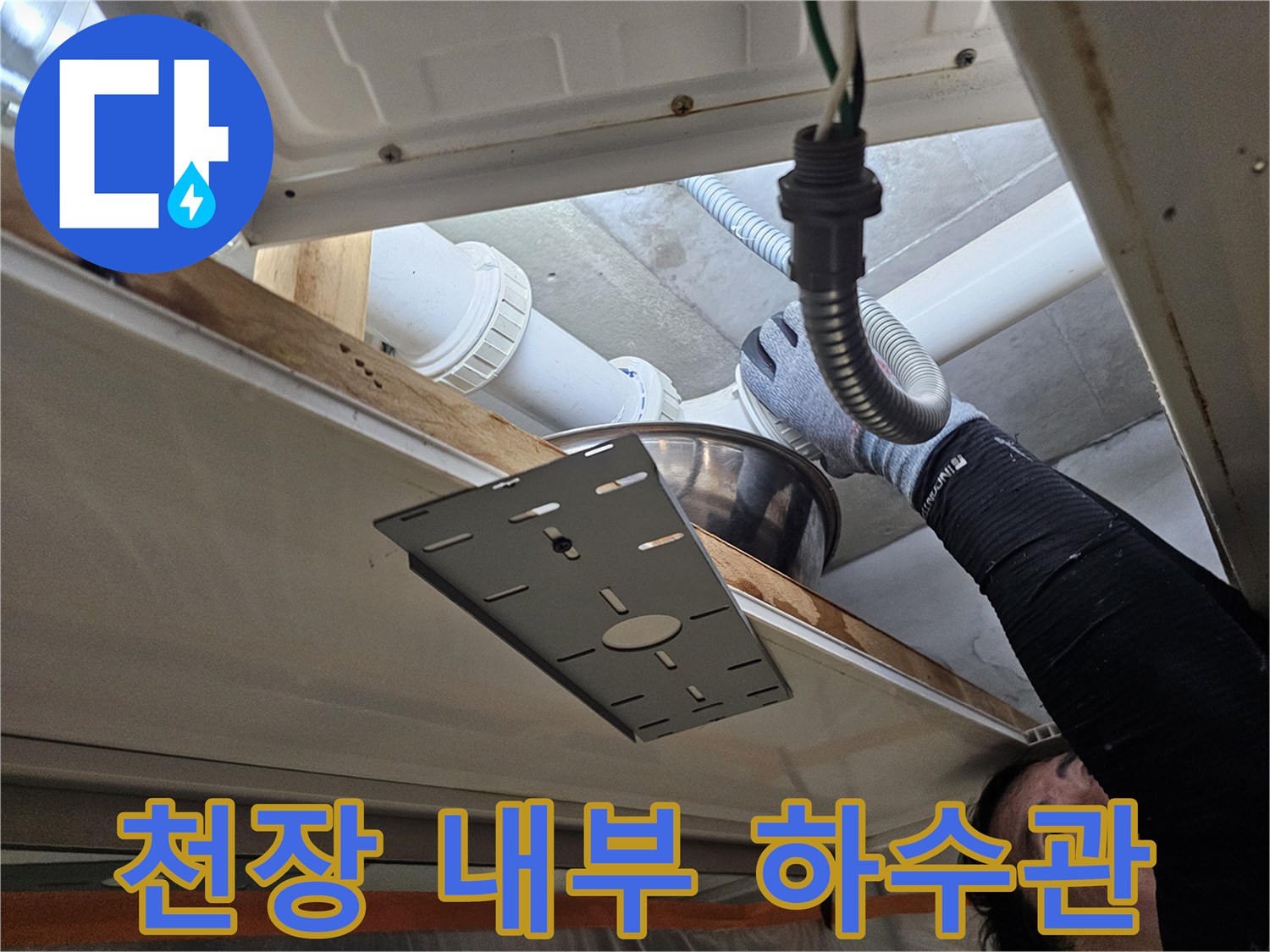 천장 점검구 안쪽의 배수용 PVC 배관과 호스 연결부