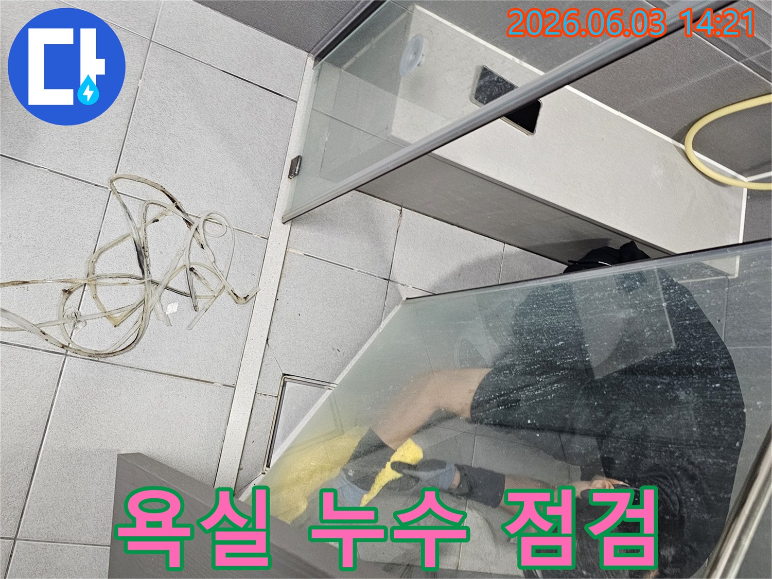 누수-전문가가-욕실-샤워부스-내부에서-정밀-점검을-진행하는-모습