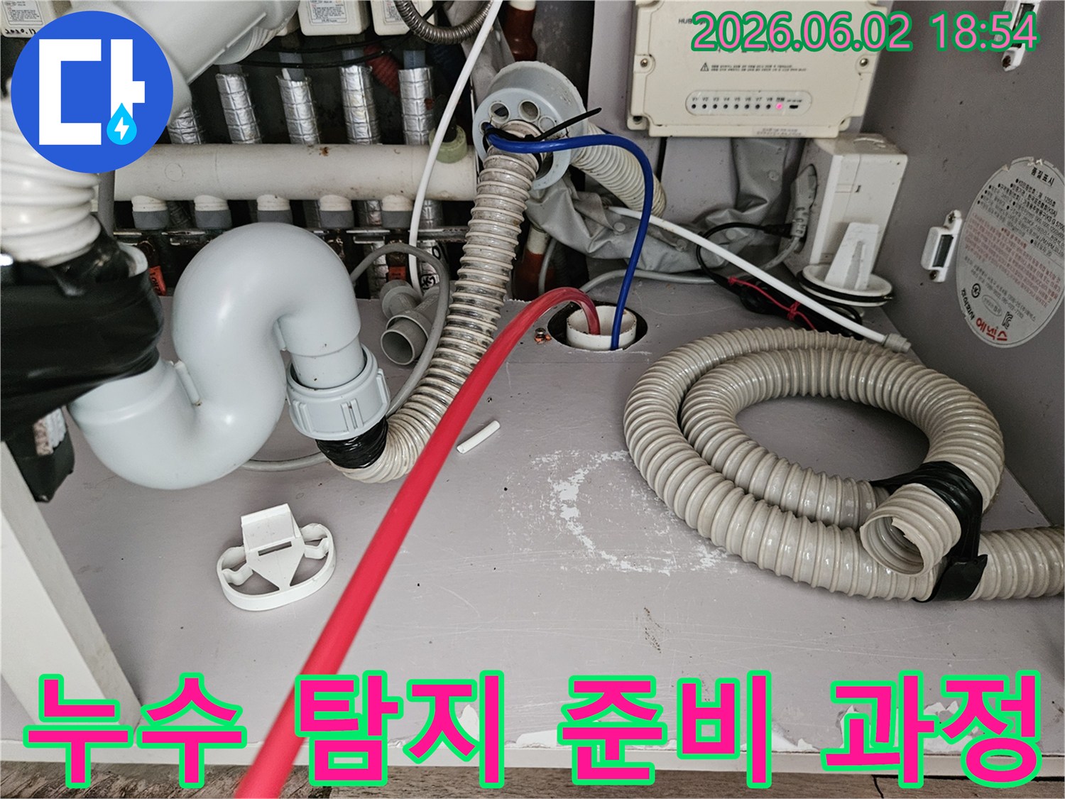 누수-탐지를-위해-보일러실-배관에-전문-장비를-연결하고-있는-작업-현장-사진