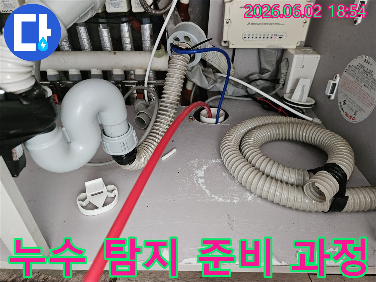 누수-탐지를-위해-보일러실-배관에-전문-장비를-연결하고-있는-작업-현장-사진