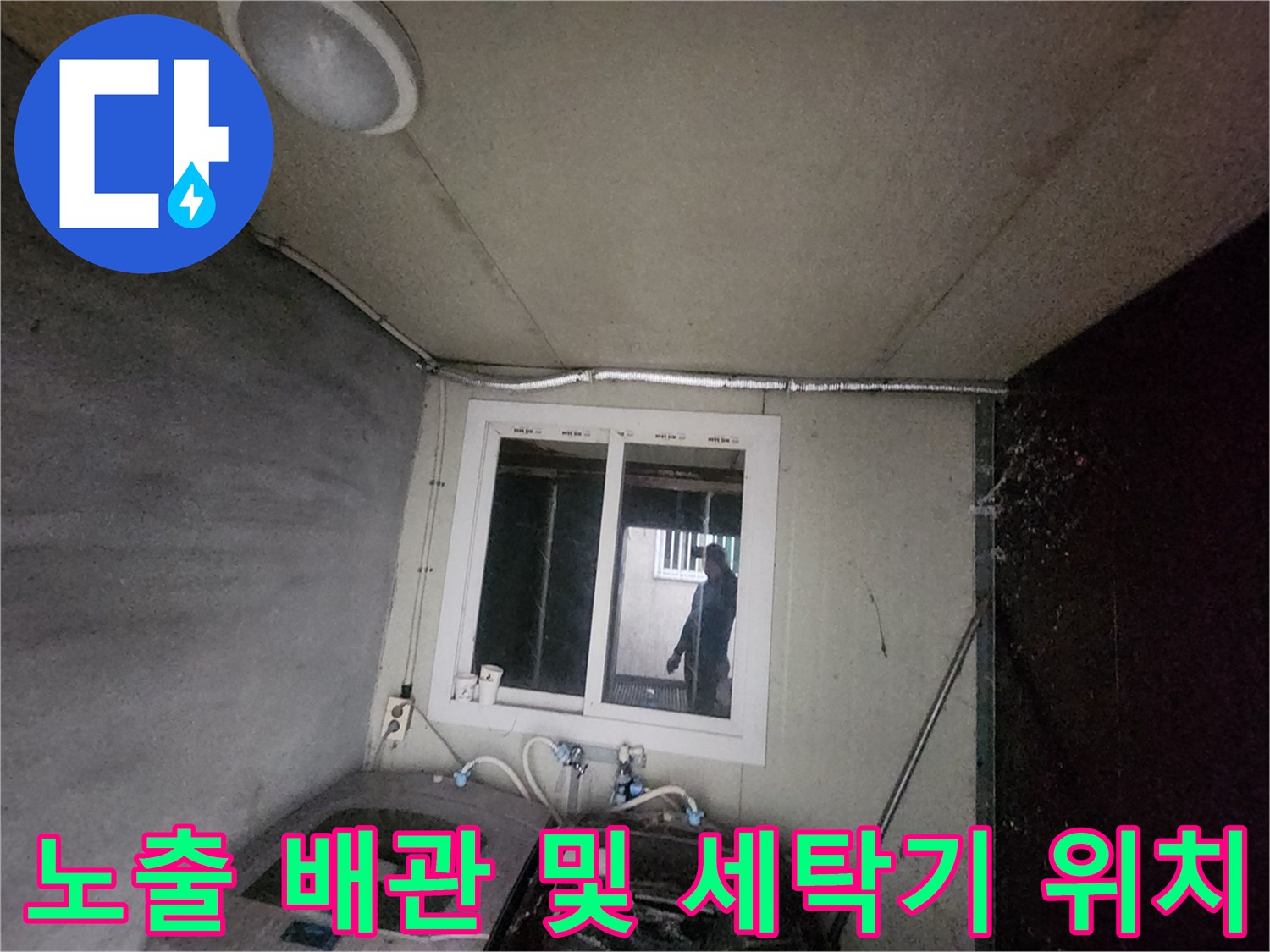 세탁기와 창문 사이에 배치된 복잡한 수동 배관 구조