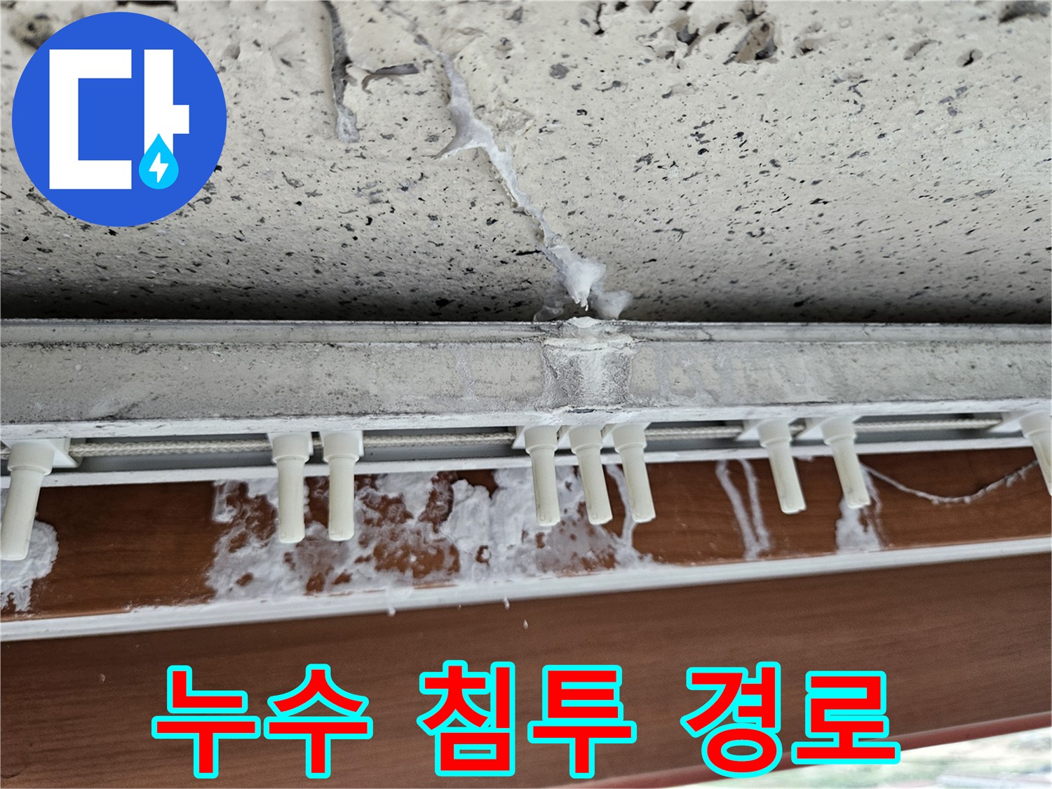 창틀 프레임 아래로 이어진 균열과 습기 자국