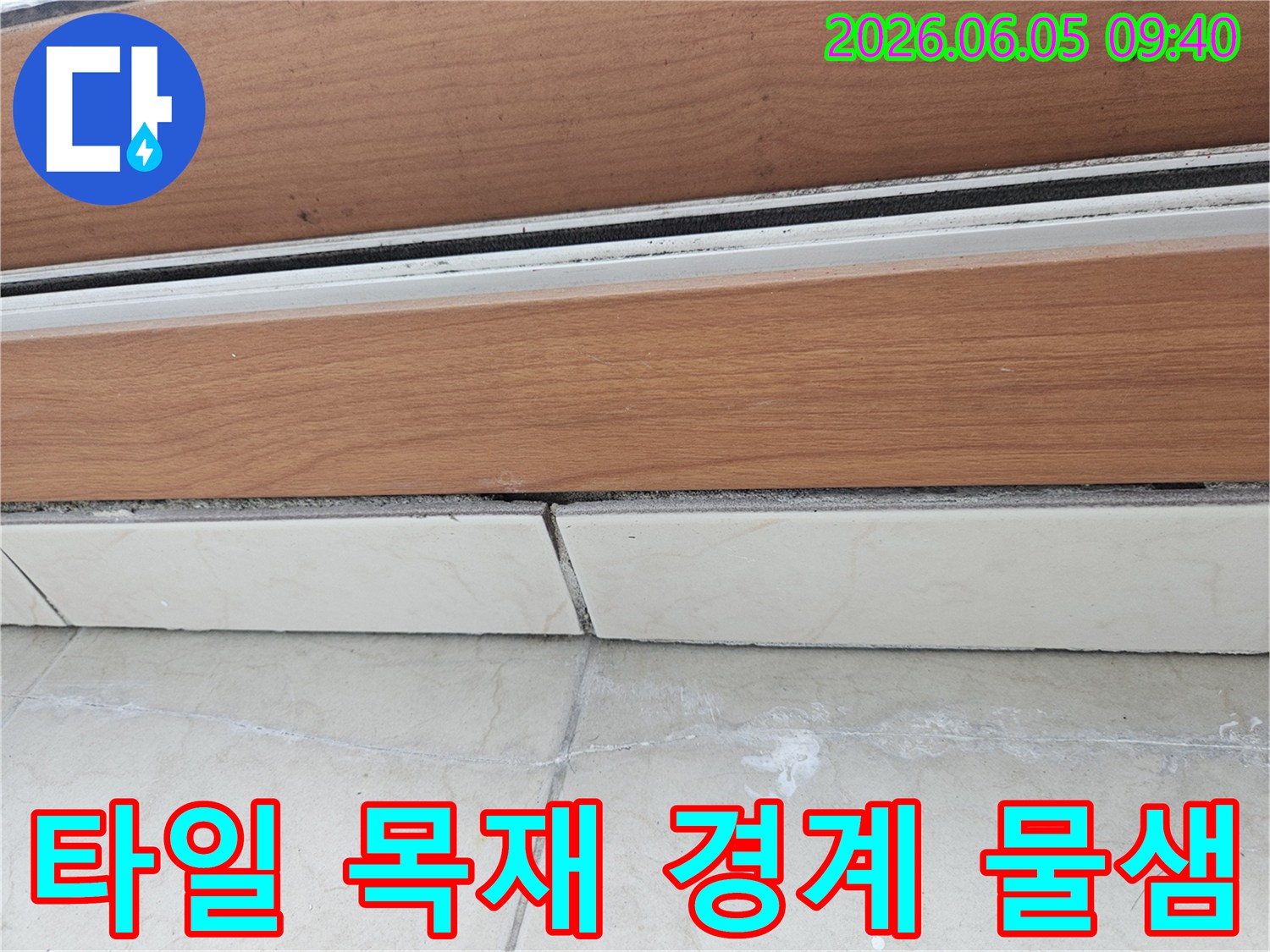 타일-바닥과-목재-마감재의-경계면에서-발생한-물샘-현장을-보여주는-사진