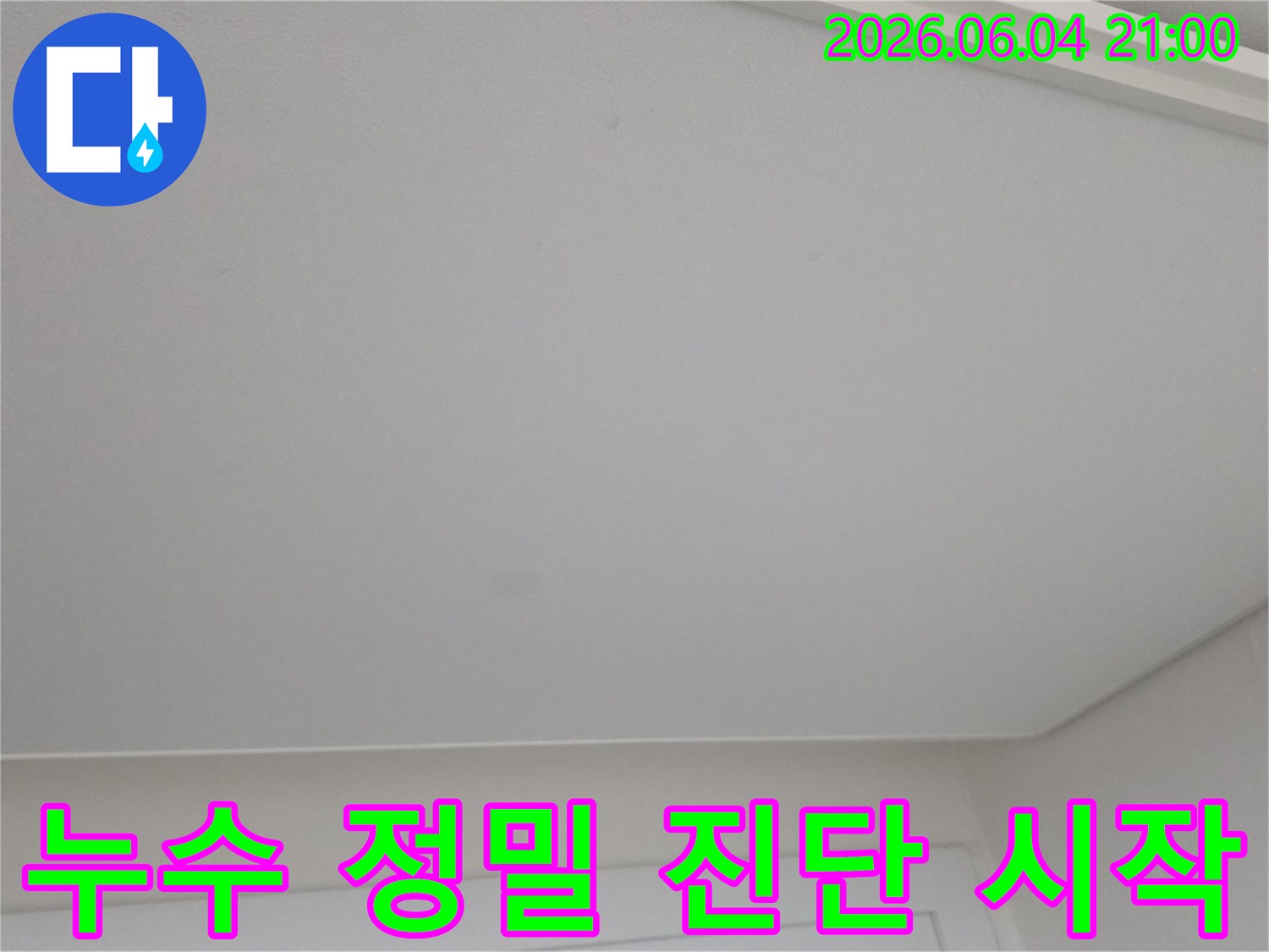 천장에 생긴 미세한 얼룩을 누수 전문가가 정밀 진단하기 시작하는 모습입니다.