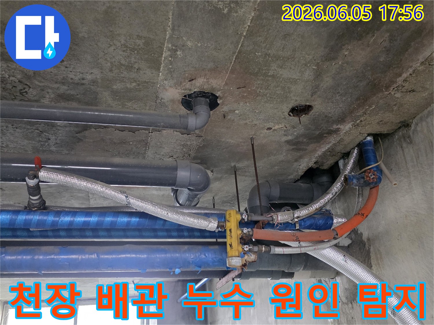 콘크리트-천장-아래-설치된-다양한-배관들의-복잡한-모습-누수-탐지-전문가가-현장을-면밀히-조사하고-있습니다