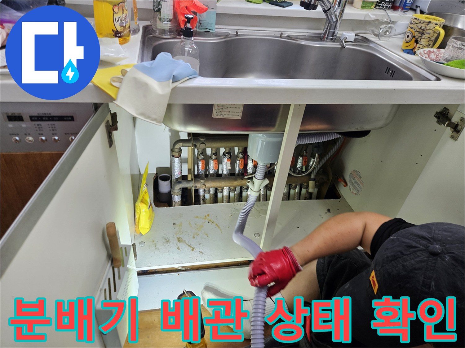싱크대 하단 분배기 부근의 엑셀 파이프와 금속 연결 부위를 점검하는 모습