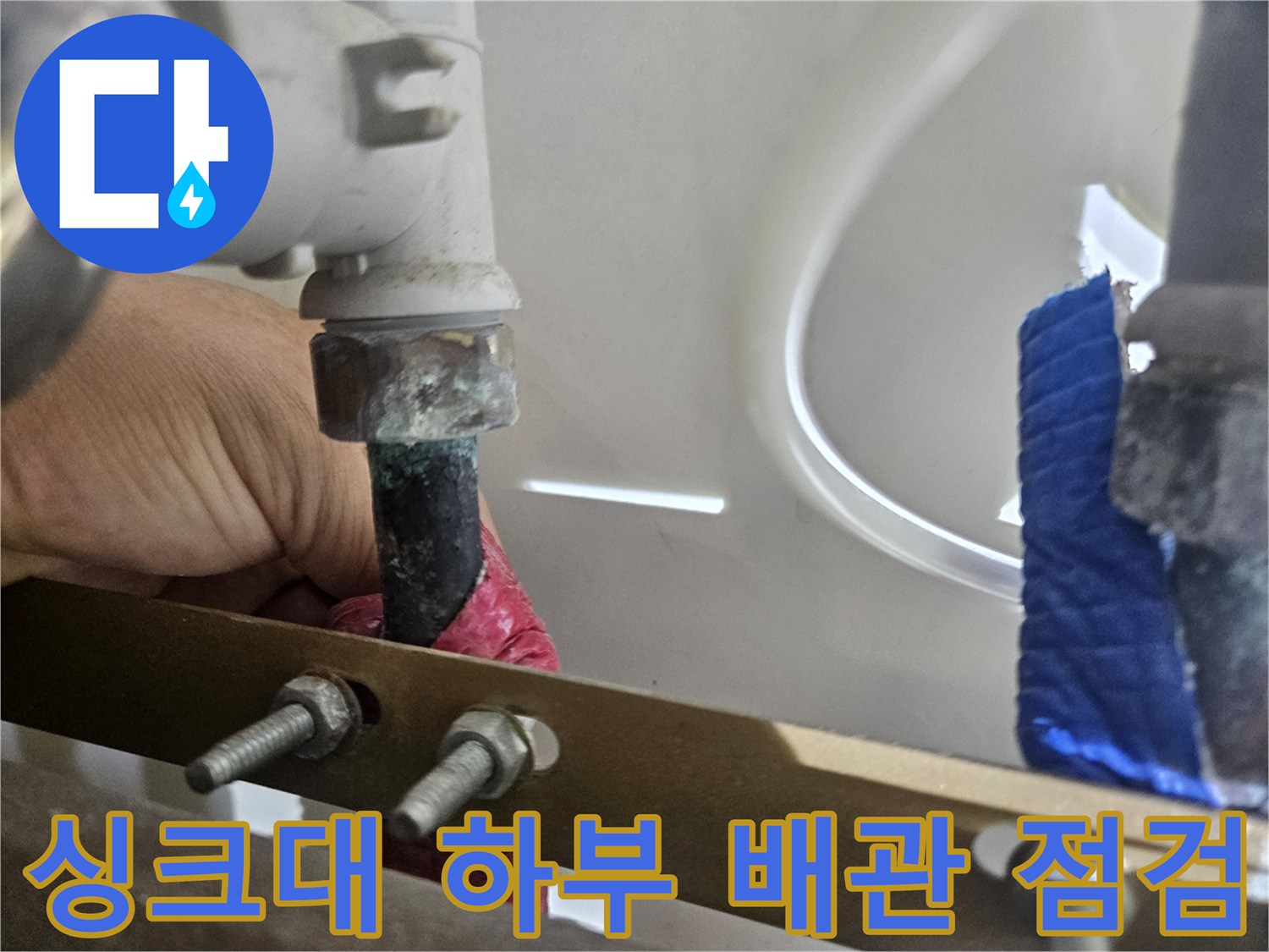 싱크대 하부의 금속 분배기와 연결된 엑셀 파이프 상태 확인 중