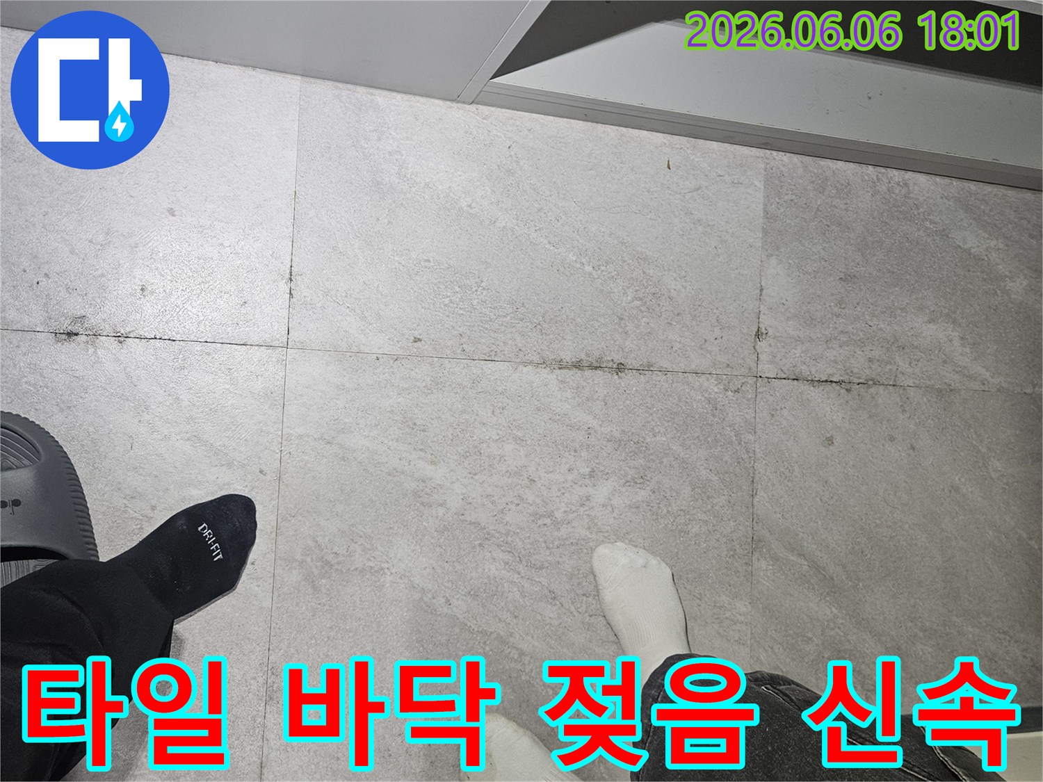 성동구-쌍용아파트-누수-현장에서-젖어-보이는-타일-바닥과-작업자의-발