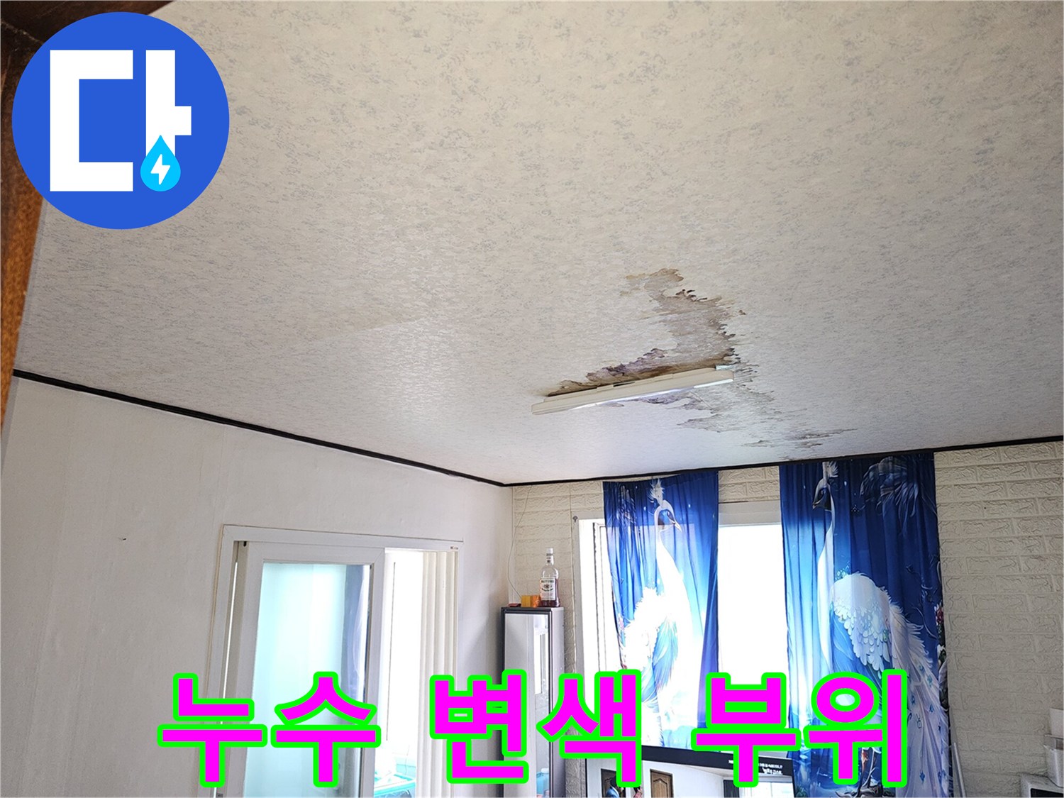 갈색으로 얼룩진 천장 벽지의 누수 피해 상태