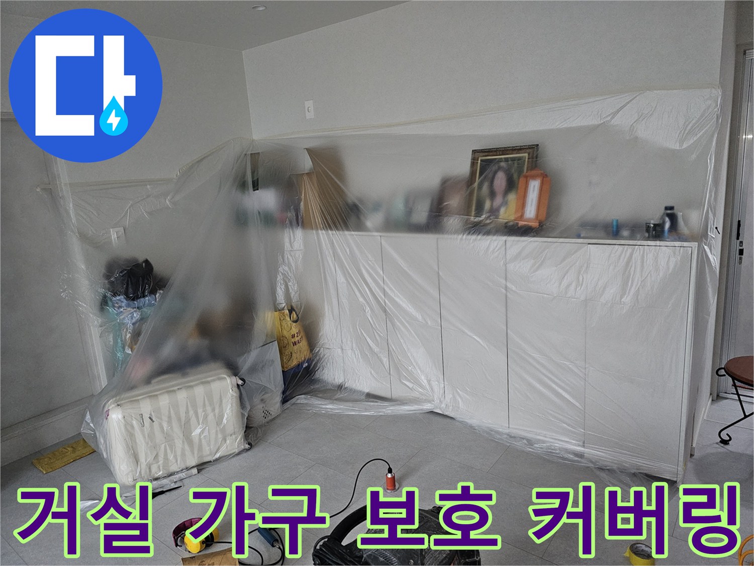 비닐로 감싸진 거실 수납장과 주변 환경 모습입니다.