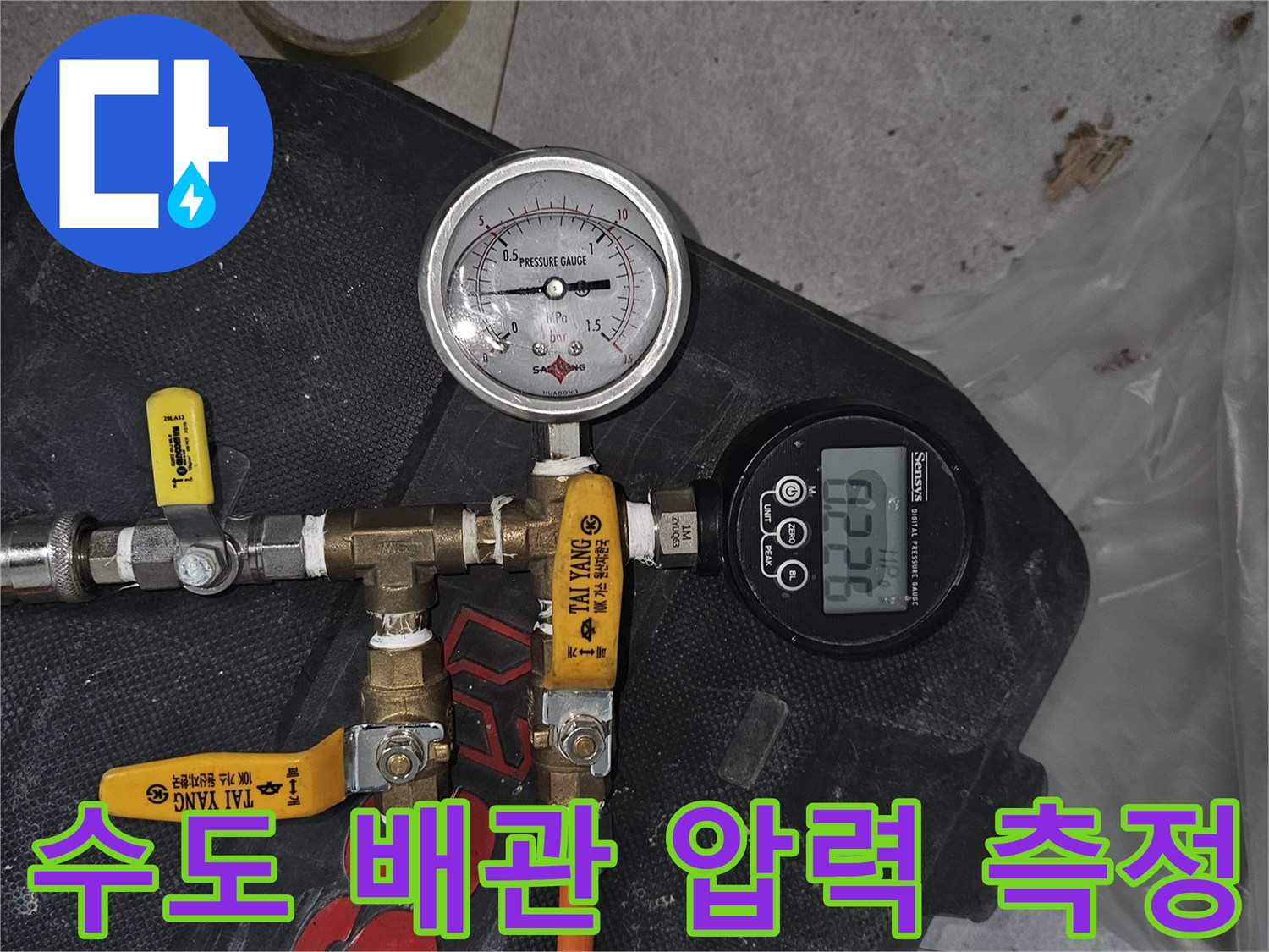 오렌지색 호스가 연결된 배관 점검용 게이지 장비