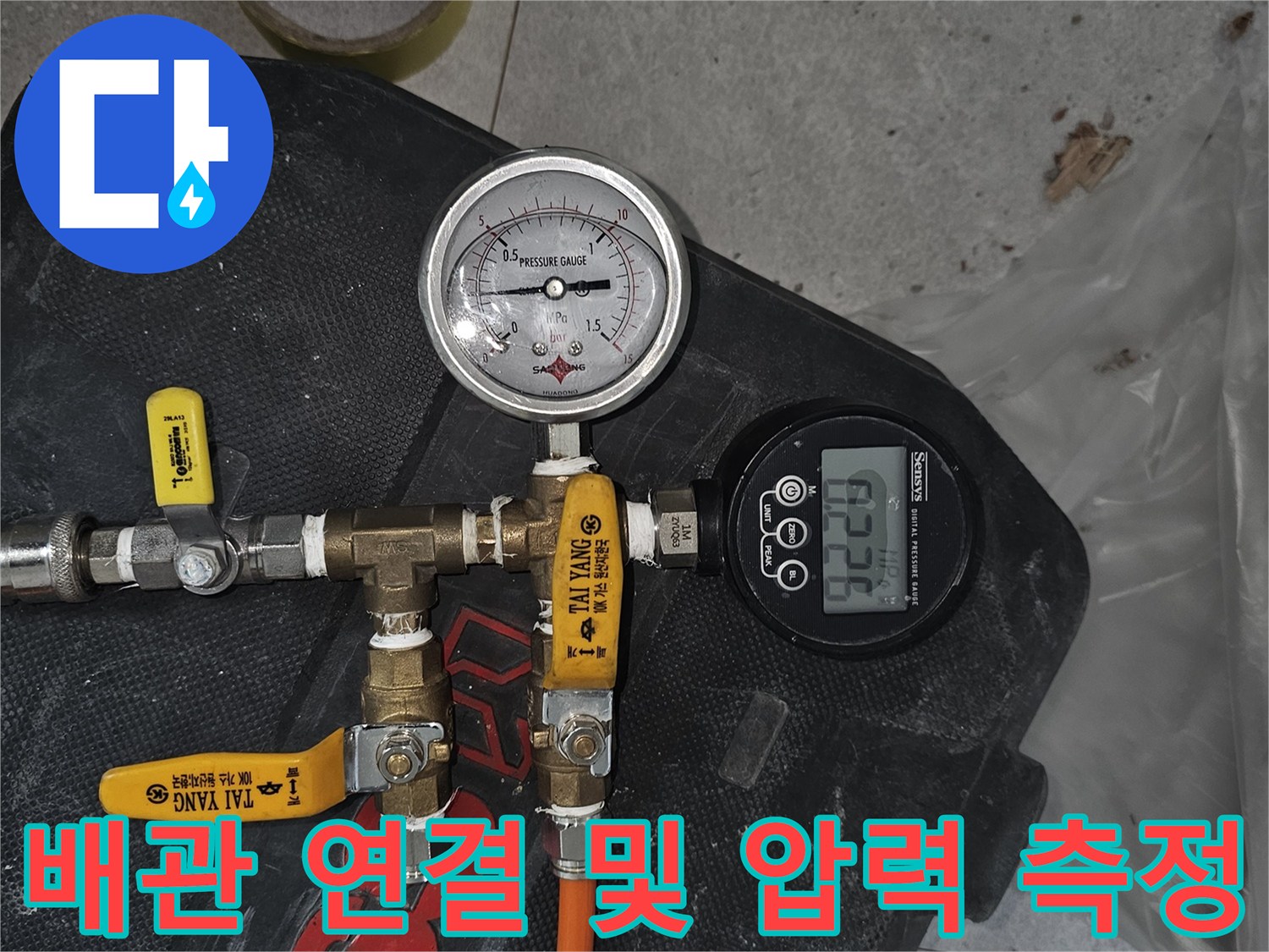주황색 호스가 연결된 배관 압력 테스트 세트