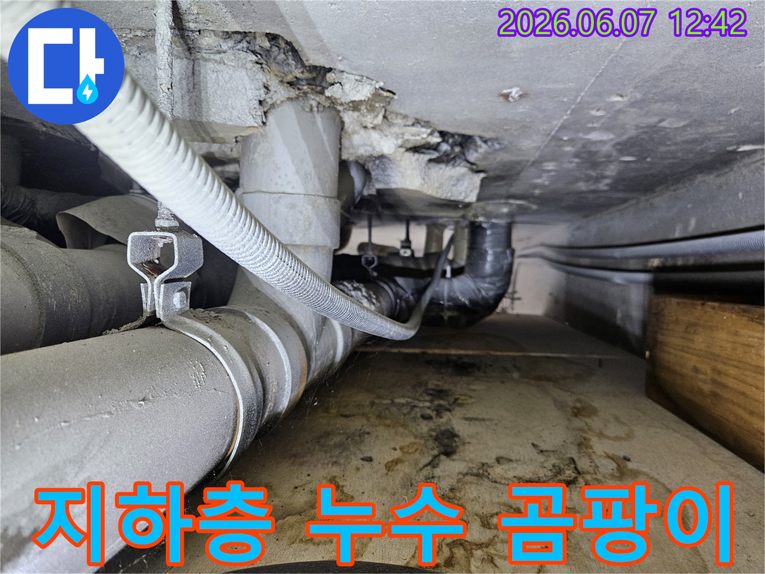 지하층 배관에서 물이 새어 나와-바닥에 물자국과-습기로 인한 곰팡이가 발생한-누수 현장의 모습입니다.