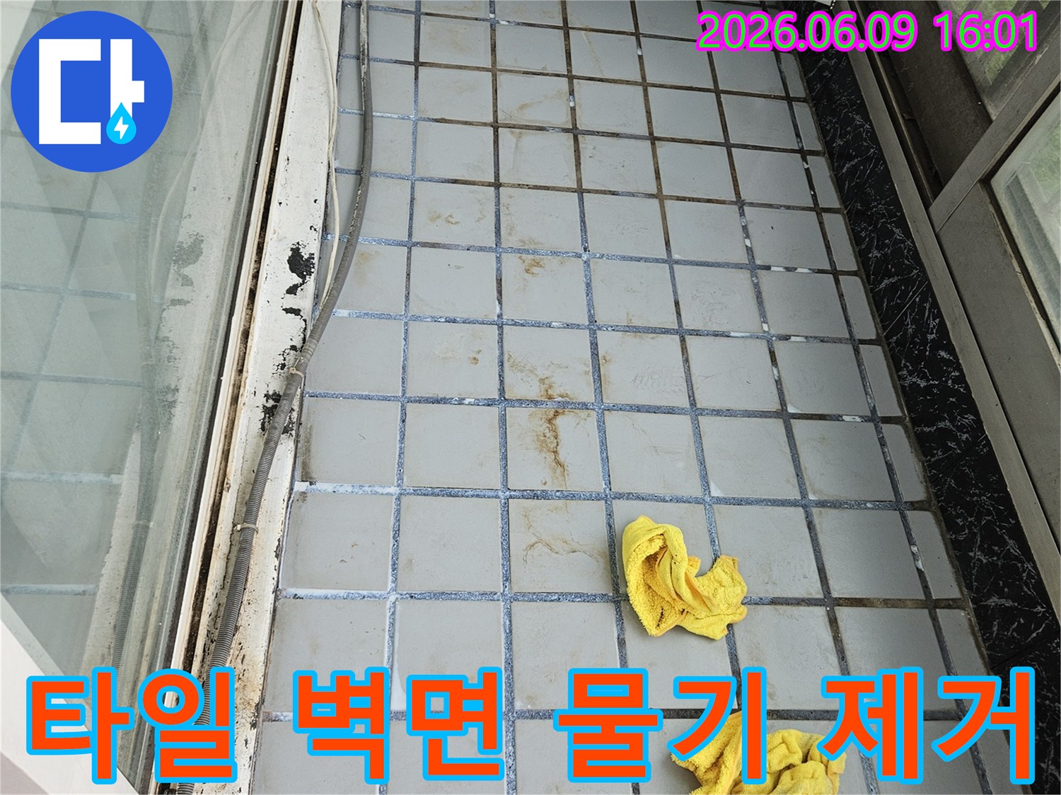 누수로 인해 젖은 타일 벽면의-물기를 전문가가 효과적으로-제거하는 작업 현장