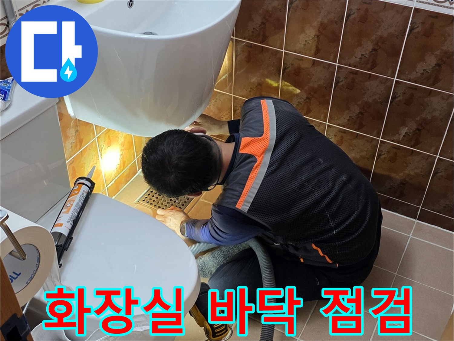 욕실 타일 사이 배관 연결부를 점검하는 기술자