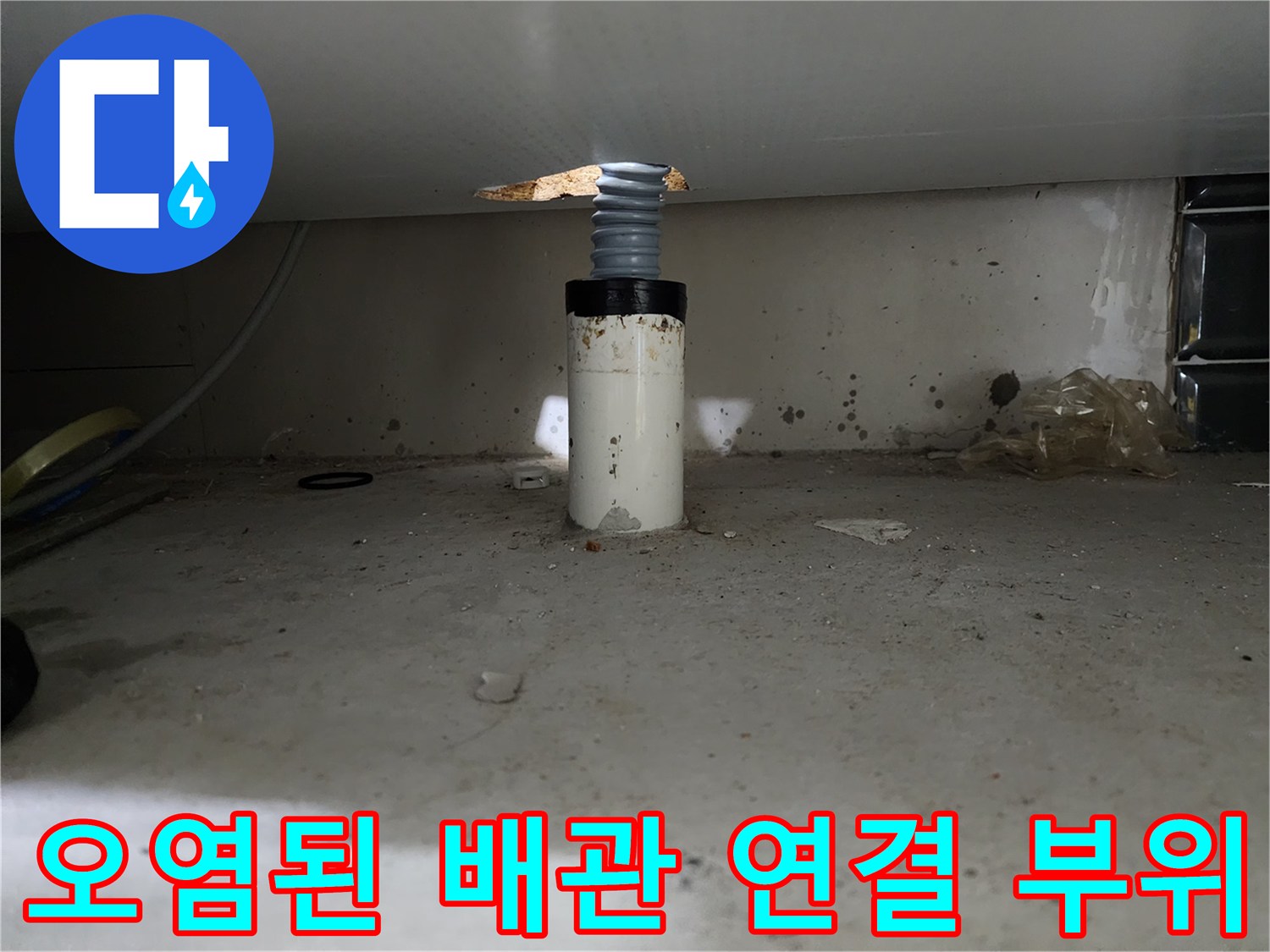 싱크대 아래쪽 배관 주변의 오염된 바닥 모습