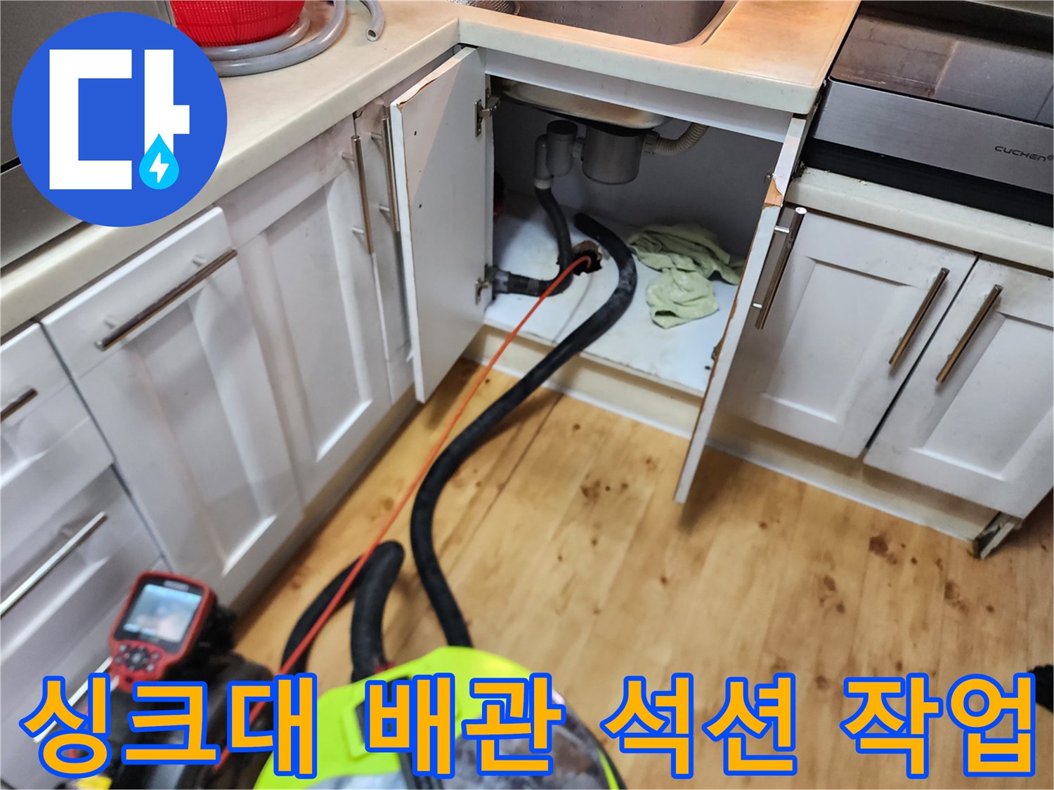 싱크대 하부장 내부-배관에 고인 물을 제거하는 석션 장비 모습