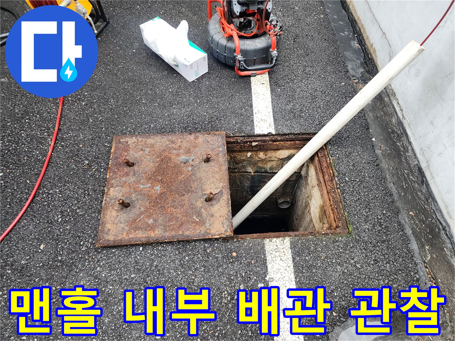 열려 있는 맨홀 덮개와 배관 진입 통로