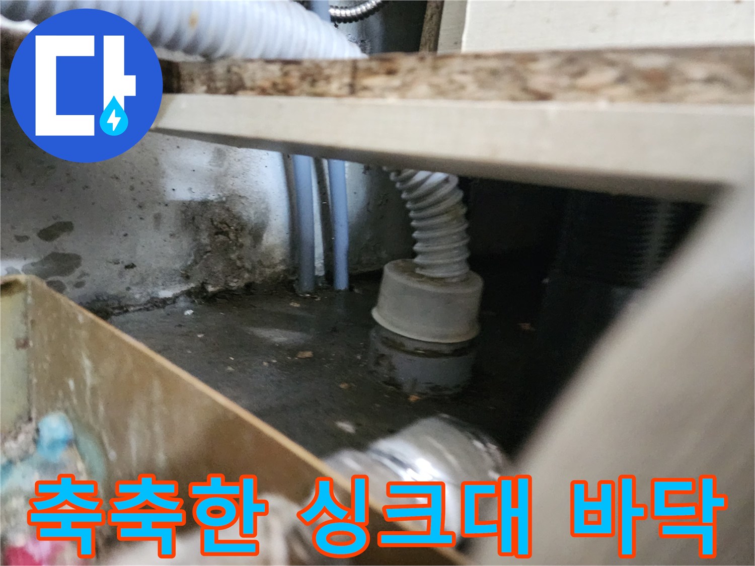 물이 역류하여 젖어 있는 싱크대 아래쪽 배관 근처 모습입니다.