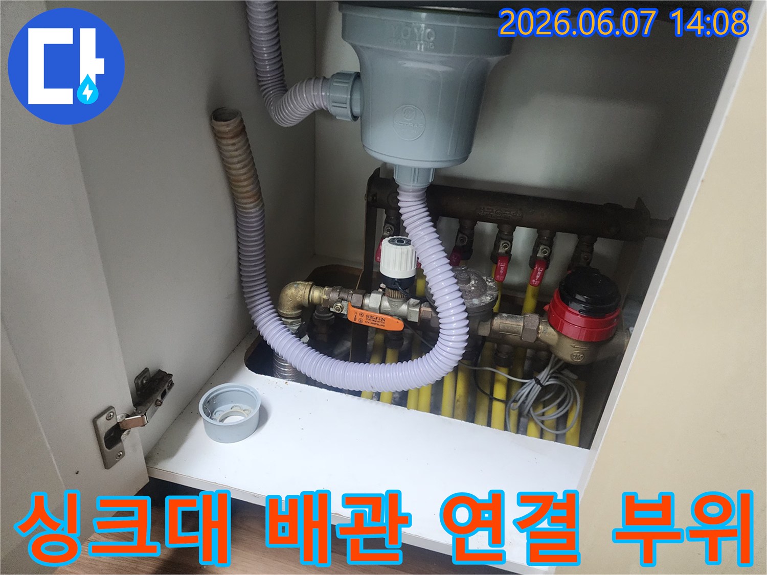 싱크대 하단에 설치된 회색 주름관과 각종 밸브의 상세 모습입니다.