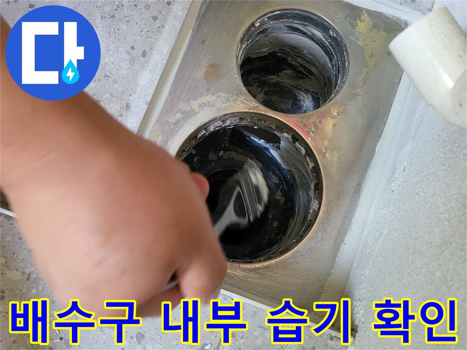 배수구 주변의 오염과 물기를 직접 점검하는 엔지니어의 작업 모습