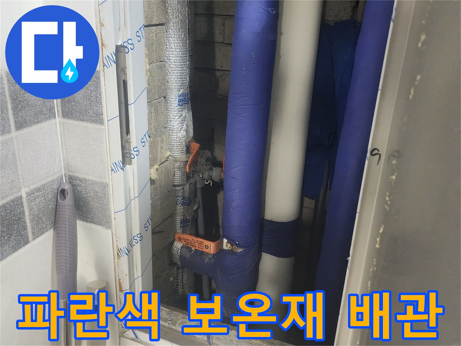 건물 내부 점검구에 보이는 파란색 단열재로 감싸진 배관 라인