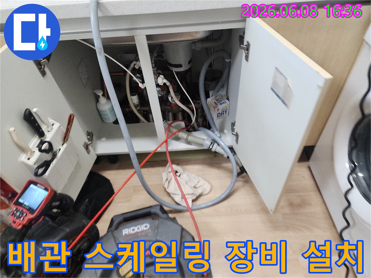 주방 싱크대 하부 배관 청소를 위해 배치된 전문 스케일링 장비