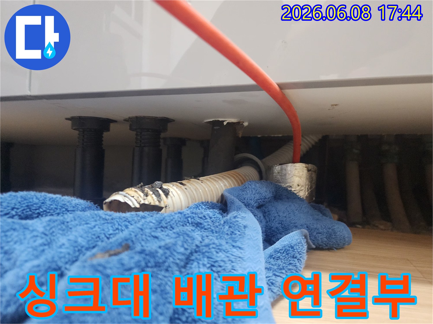 싱크대 하부장 내부의 배관과 주름관 연결 부위 점검 사진
