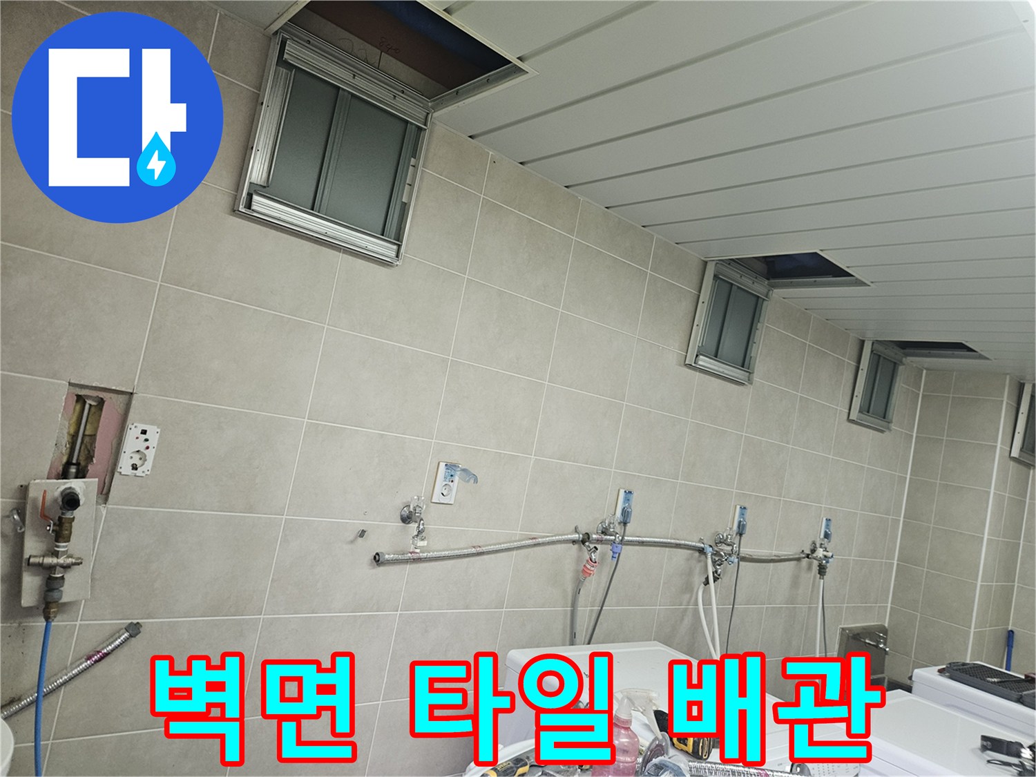 조종면 세탁실 벽면-타일과 노출된 급수 부속들