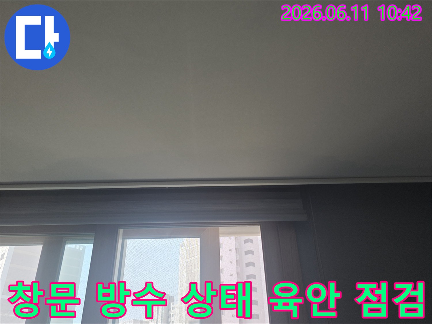 아파트 창문 주변의 방수 상태를-육안으로 확인하며-누수 가능성을 진단하는 사진입니다.