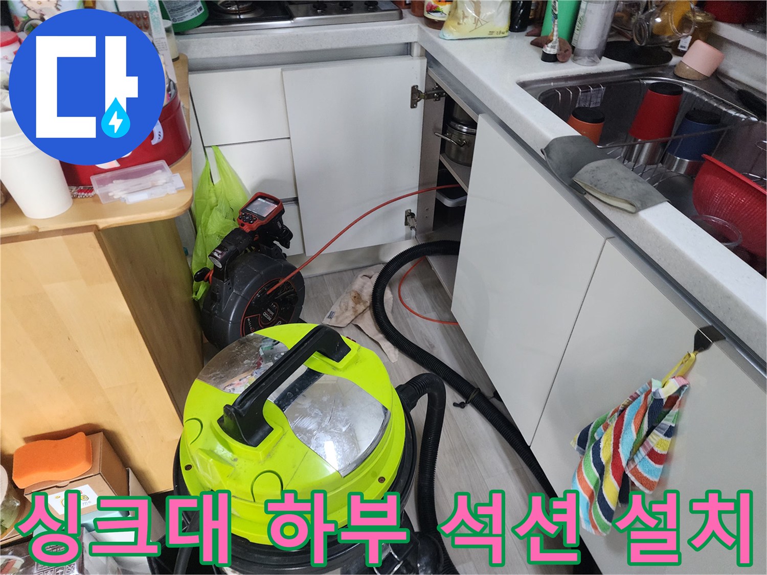 싱크대 아래쪽 배수관 청소를 위해 설치된 전문 석션기와 연결 호스입니다.
