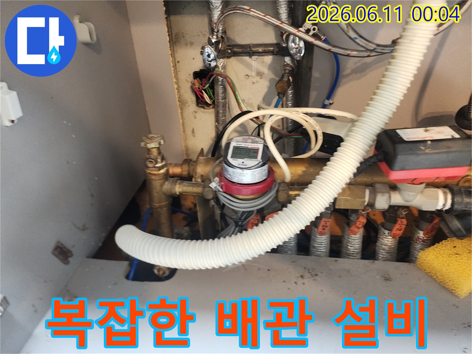온수기와 연결된 다양한 금속 및 플라스틱 배관 구조