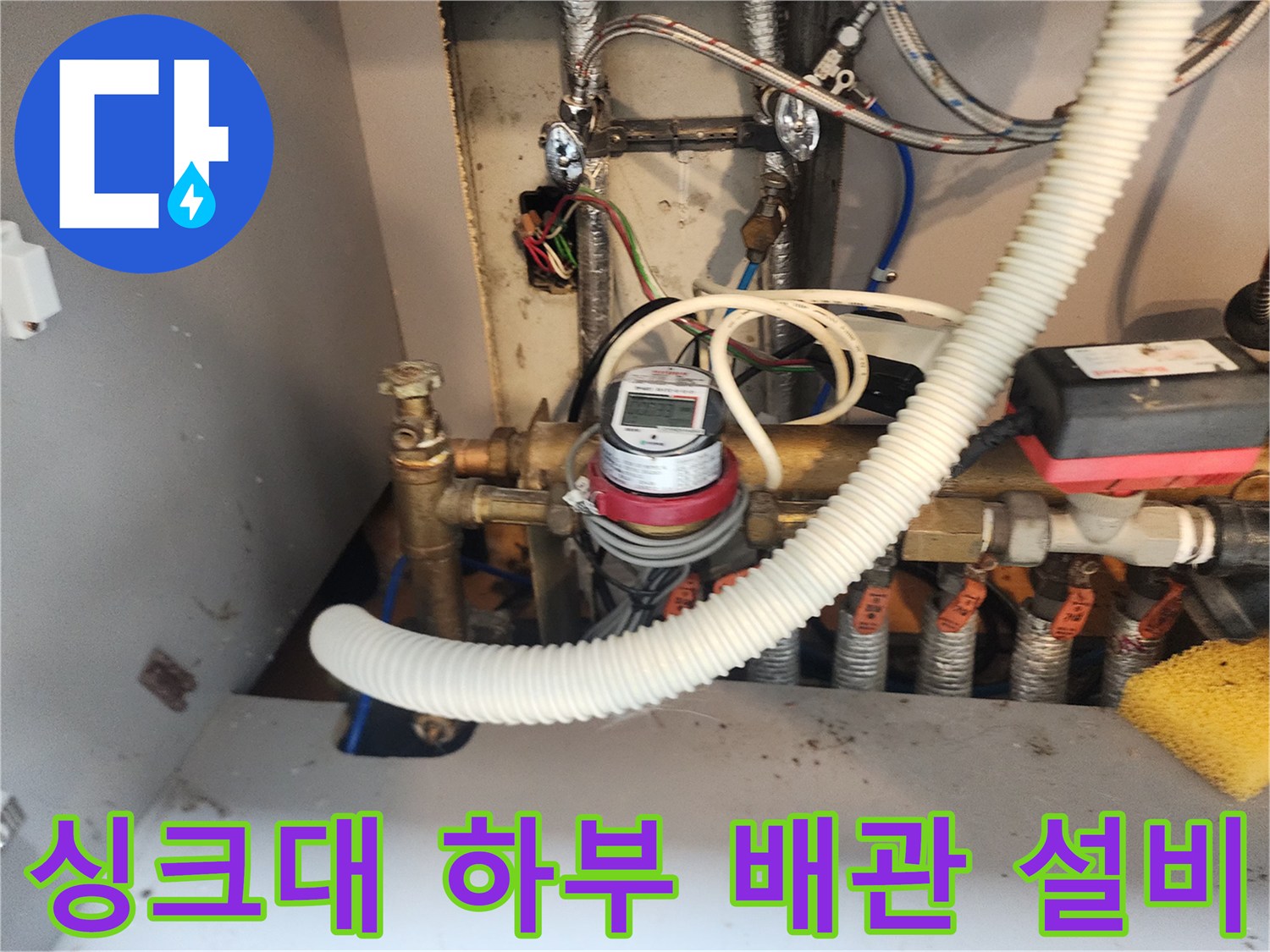 주방 싱크대 아래쪽 수도 계량기와 연결된 금속 밸브들