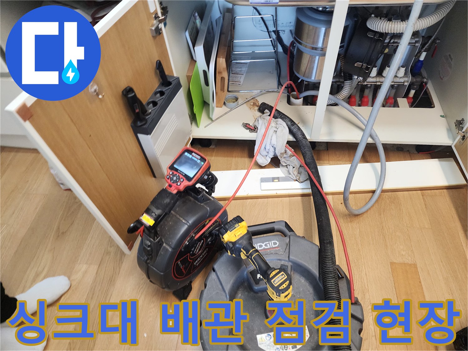 싱크대 아래쪽 꽉 막힌 배관을 청소하기 위해 배치된 전문 장비들입니다.