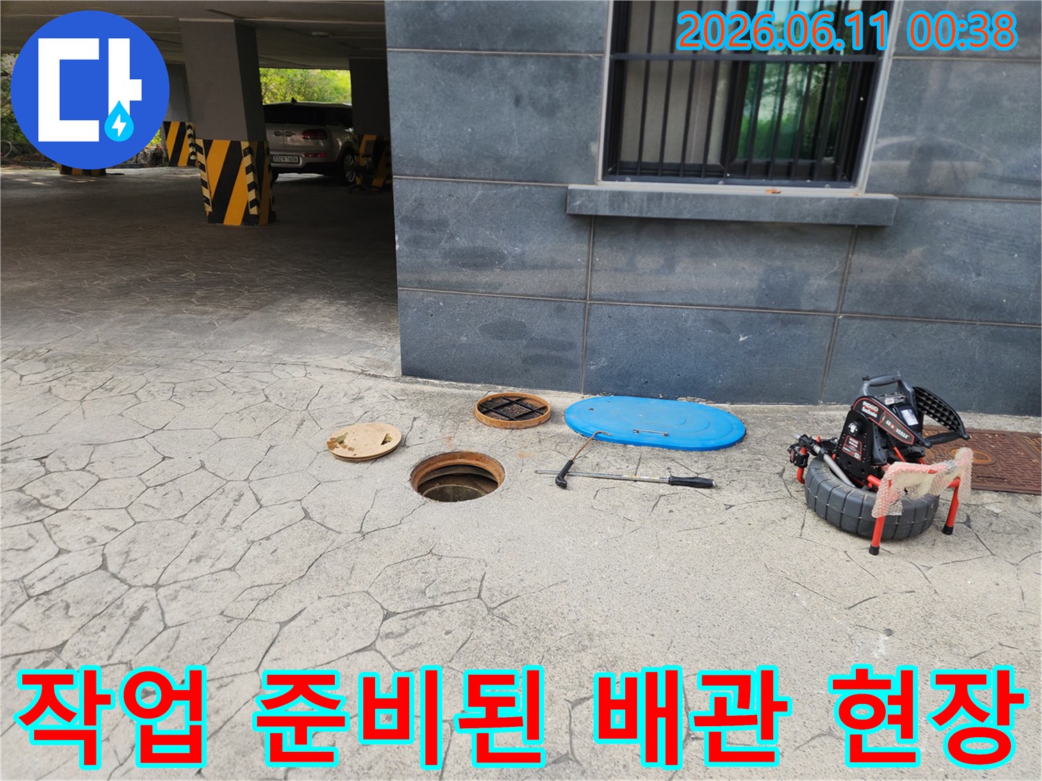 주차장 바닥 맨홀 주변의 작업 도구와 덮개
