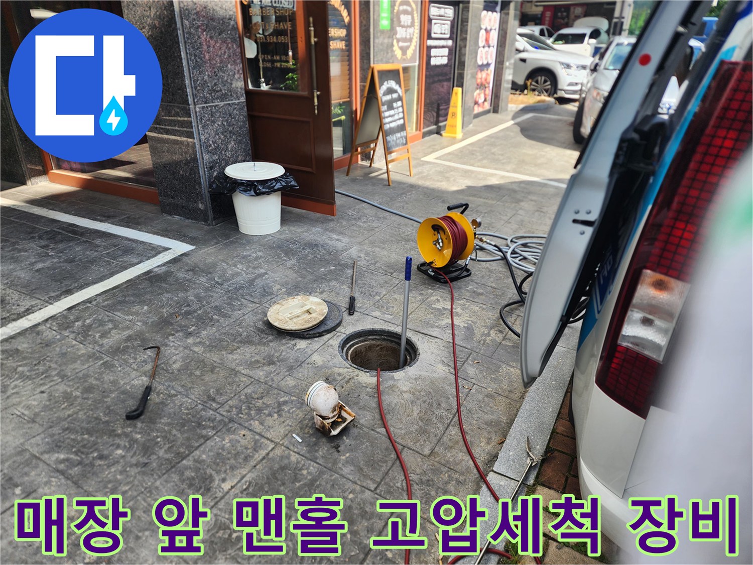 김포 북변동 매장 앞 도로에 설치된 맨홀과 고압 세척용 호스 릴 장비 모습