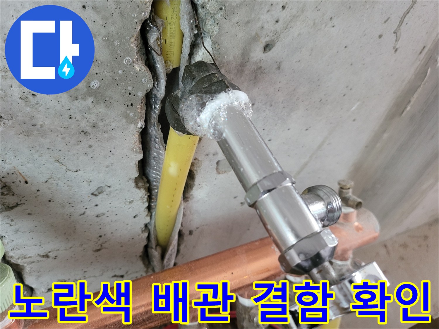파헤쳐진 콘크리트 바닥 사이의 노란색 수도 배관 모습