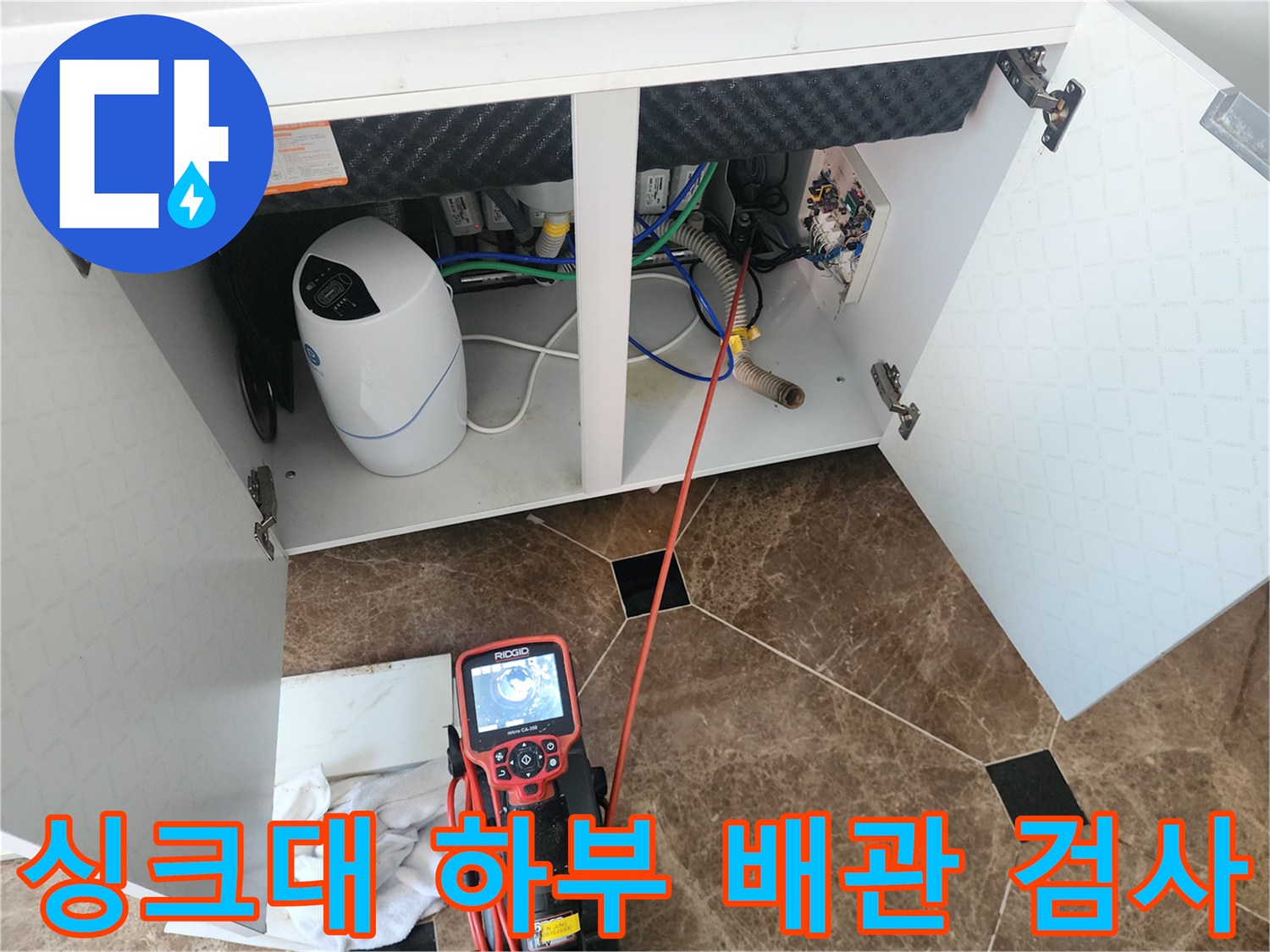 싱크대 아래쪽 배관 연결 부위와 내시경 모니터의 모습