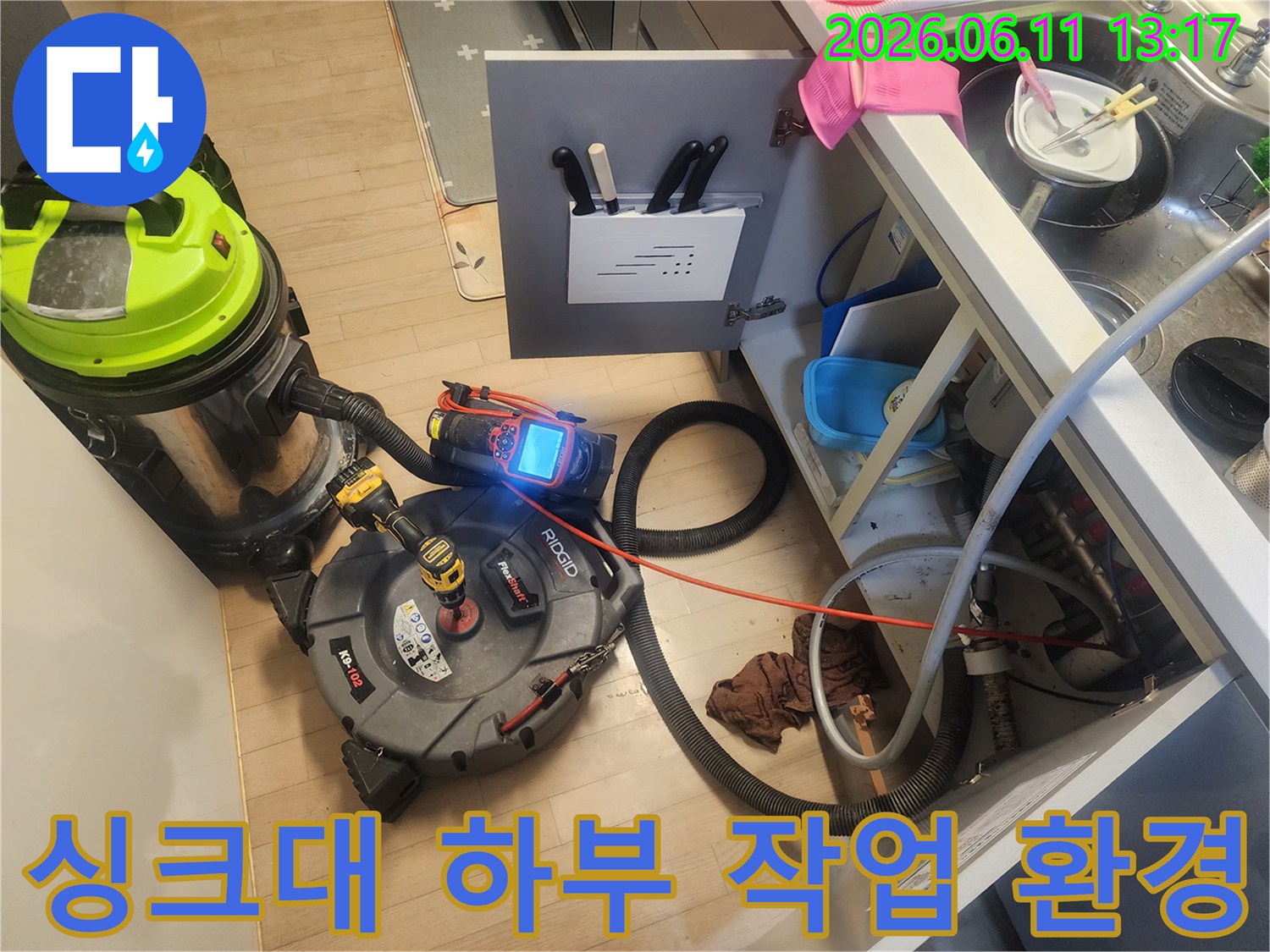 싱크대 밑 공간에 준비된 배관 스케일링기와 강력 석션기 장비 모습