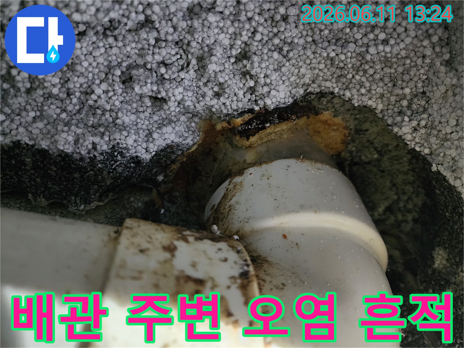 흰색 배관과 단열재 사이의 갈색 슬러지 오염