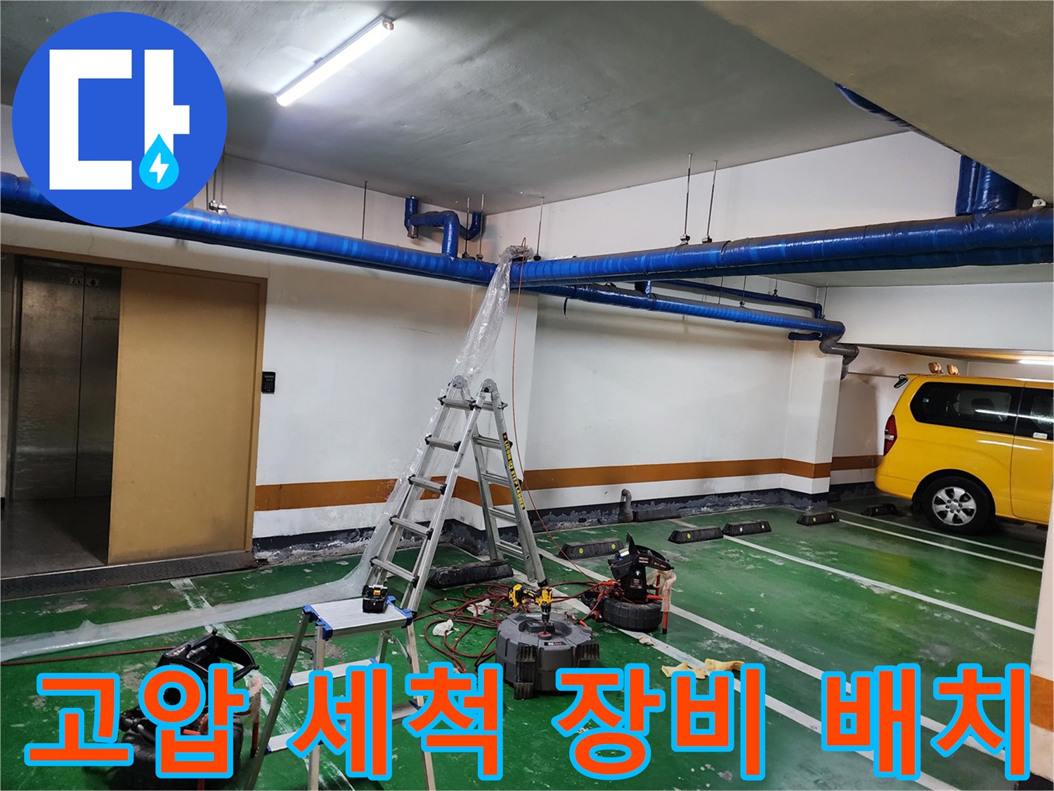 지하주차장 바닥에 놓인 고압 세척기와 천장 작업을 위한 사다리