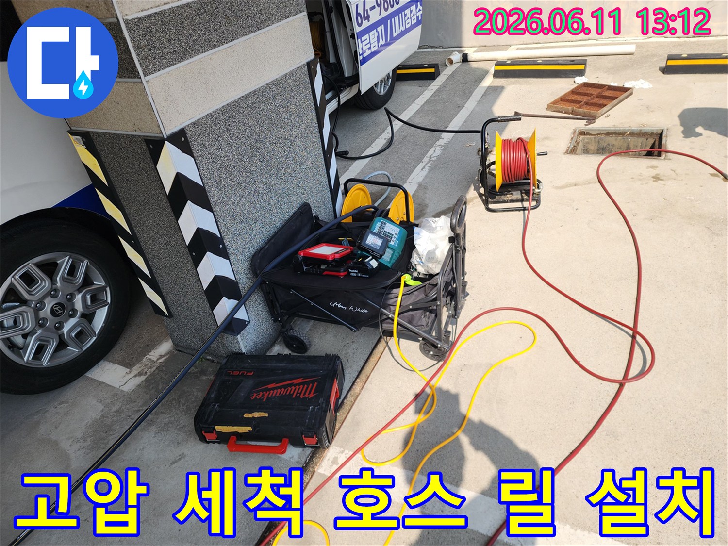 작업을 위해 건물 옆에 배치된 고압 호스 릴과 공구함