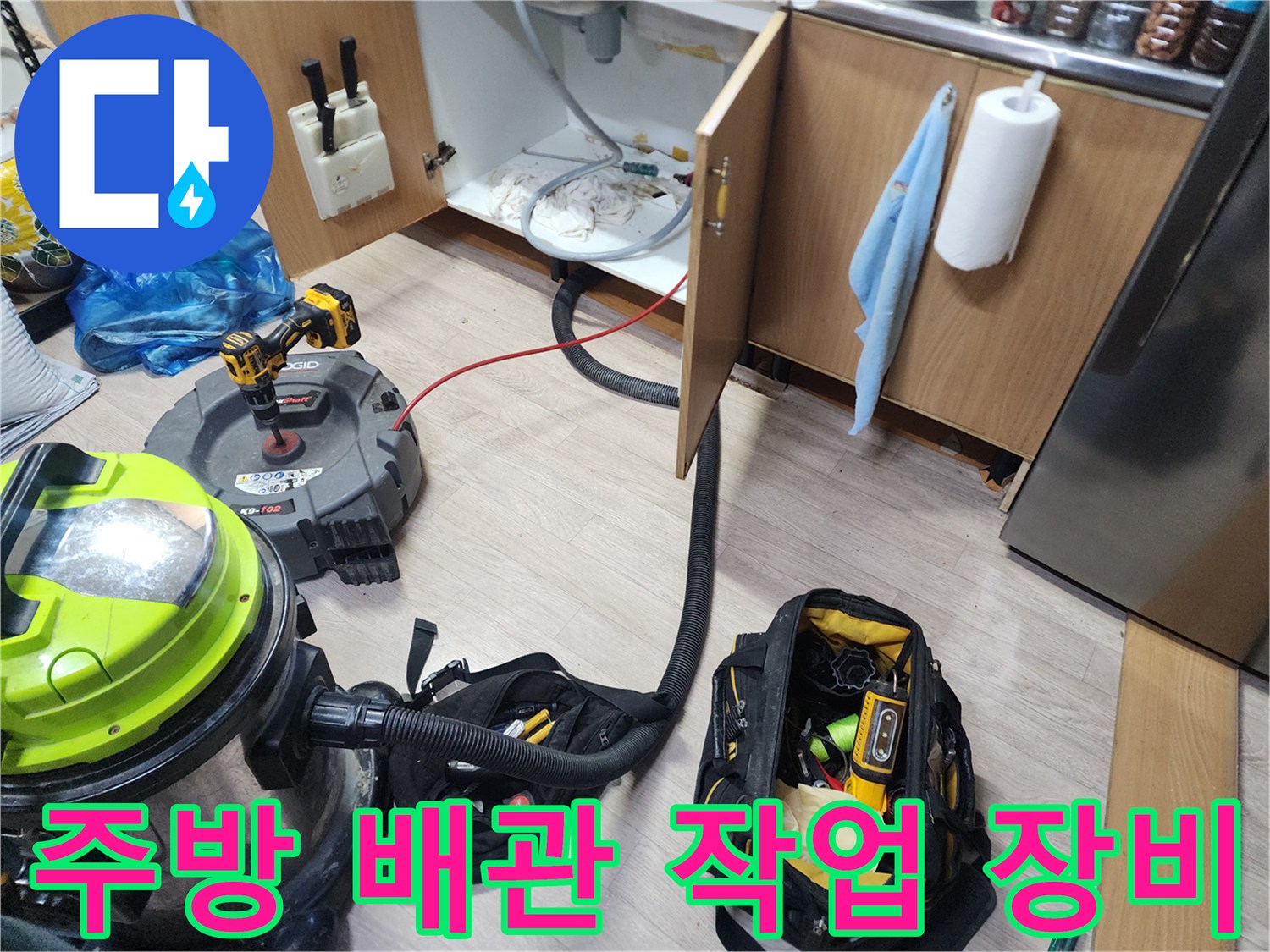 주방 싱크대 하부장 아래에 배치된 석션기와 전문 작업 도구 세트