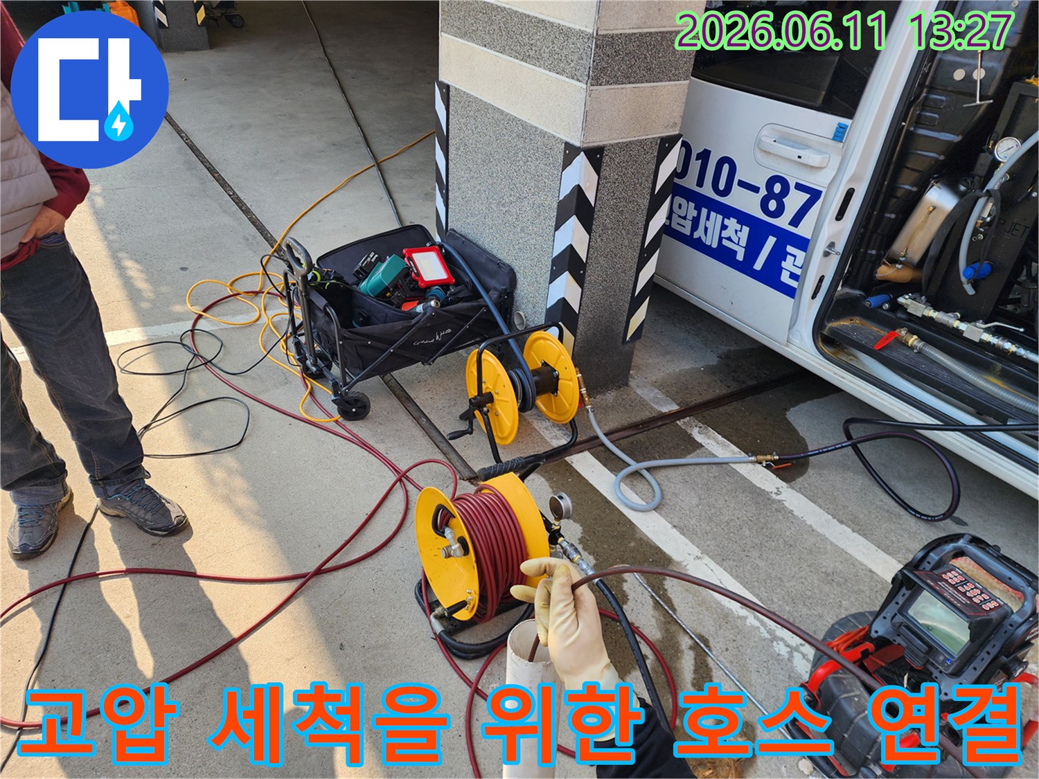 차량에서부터 길게 이어진 고압 세척용 노란색 호스와 장비들
