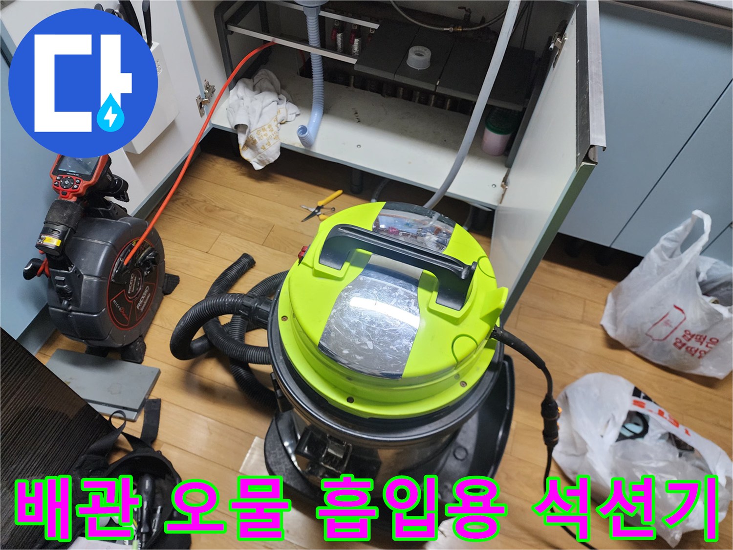싱크대 하부 배관 청소를 위해 가동 중인 강력한 진공 석션 장비