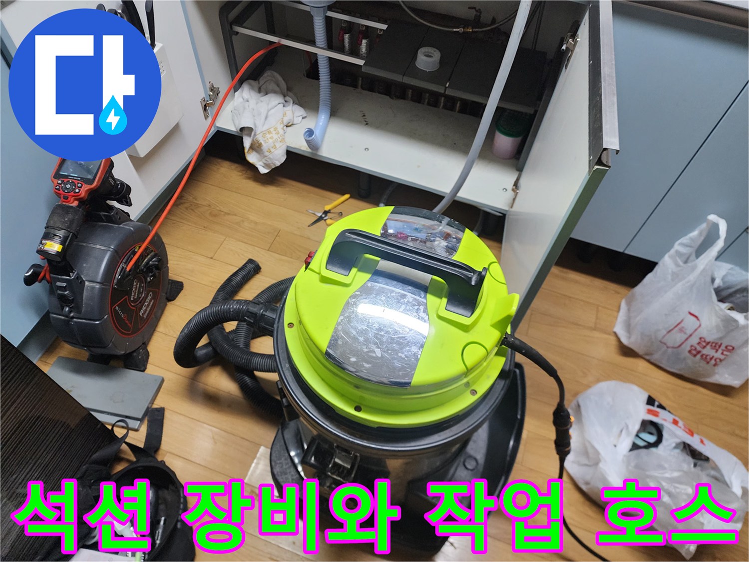 싱크대 하부장 내부의 배관 청소를 위한 석션기 설치 모습
