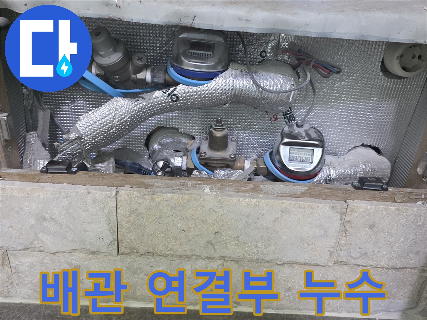 보온재로 감싸진 배관의-연결 부위와-수도 계량기가 보이는-누수 탐지 현장입니다