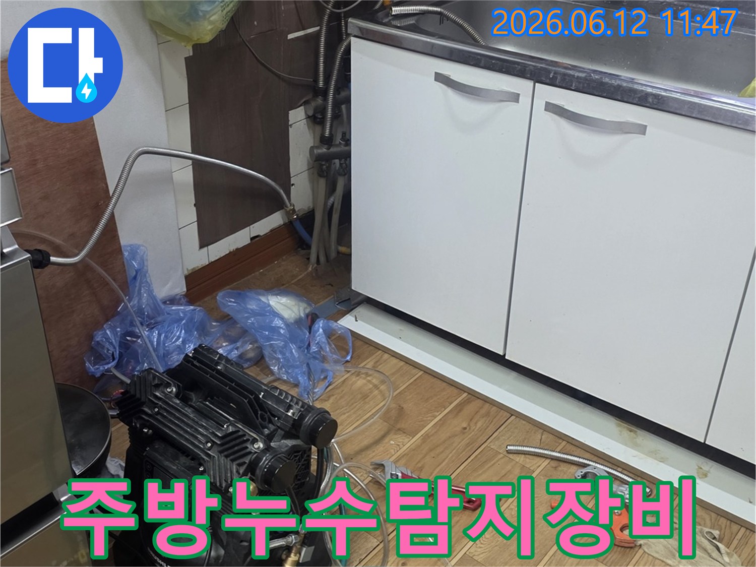 싱크대 아래에서-누수 탐지 장비와-공구들이 놓여있는-작업 현장 모습
