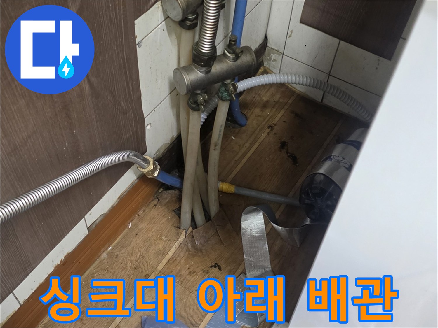 싱크대 하단 은색 자바라 배관과 연결 부품의 근접 촬영