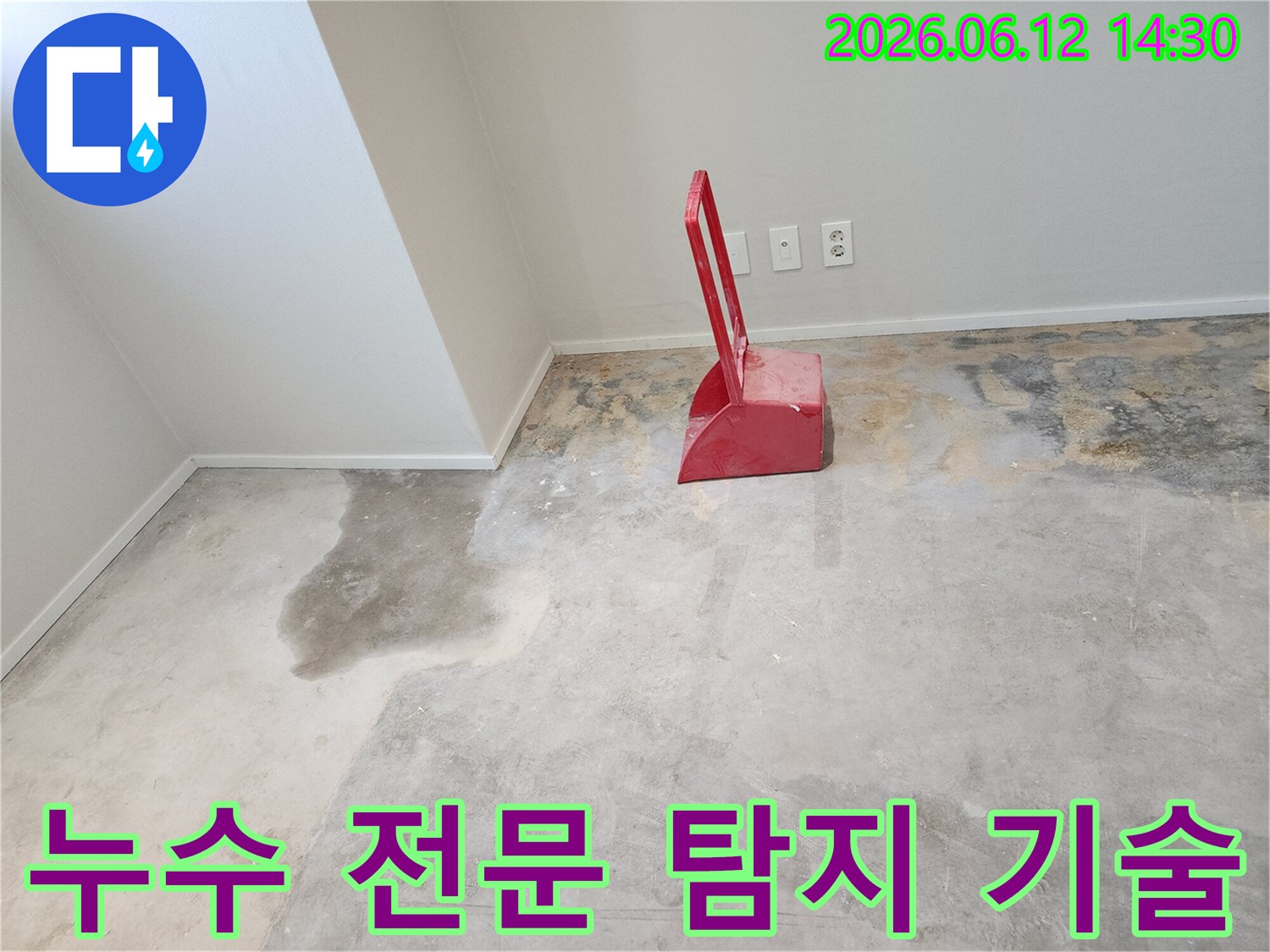 누수-현장에서-콘크리트-바닥이-젖어있고-빨간색-청소-도구가-놓여있는-모습